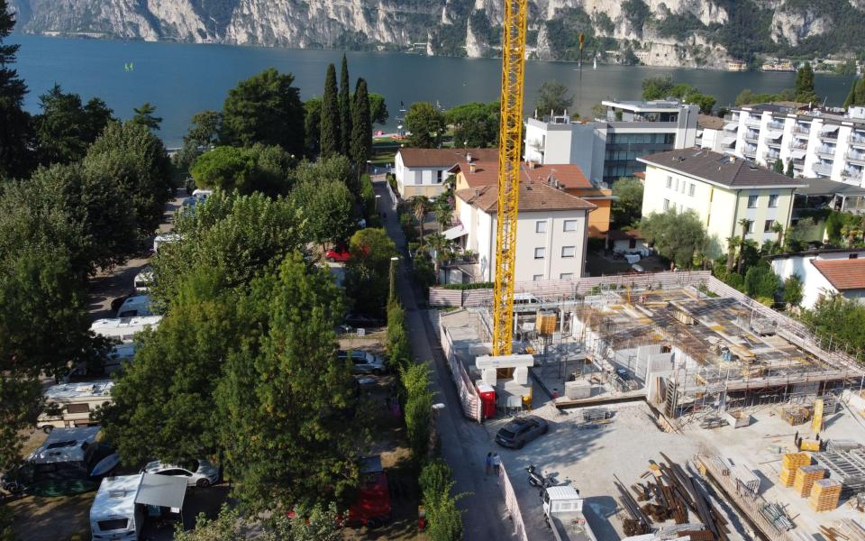 Cantiere vicino al lago con edifici e gru.